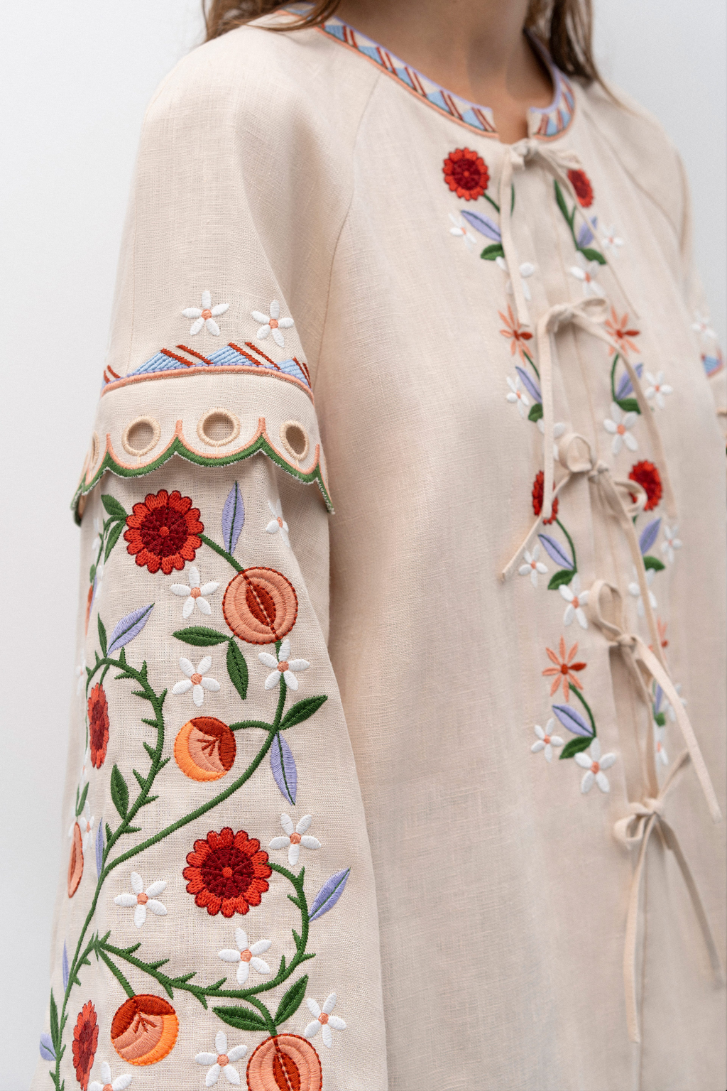 Beige garment with floral embroidery on a plain background