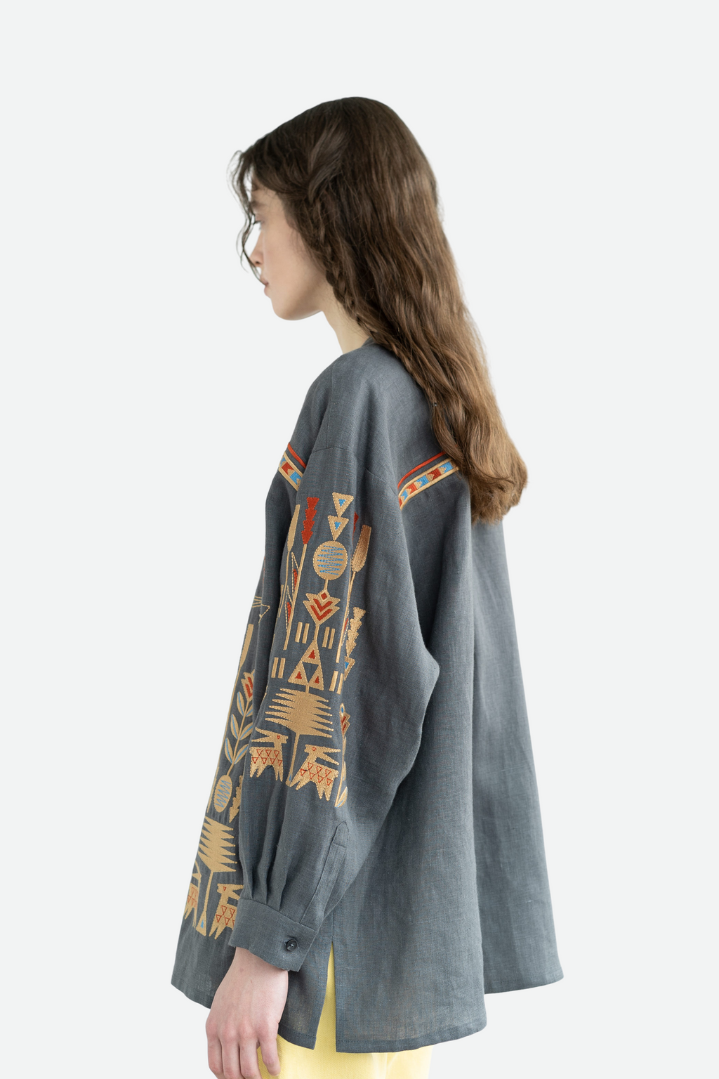 Woman wearing a gray sweater with geometric patterns on a white background