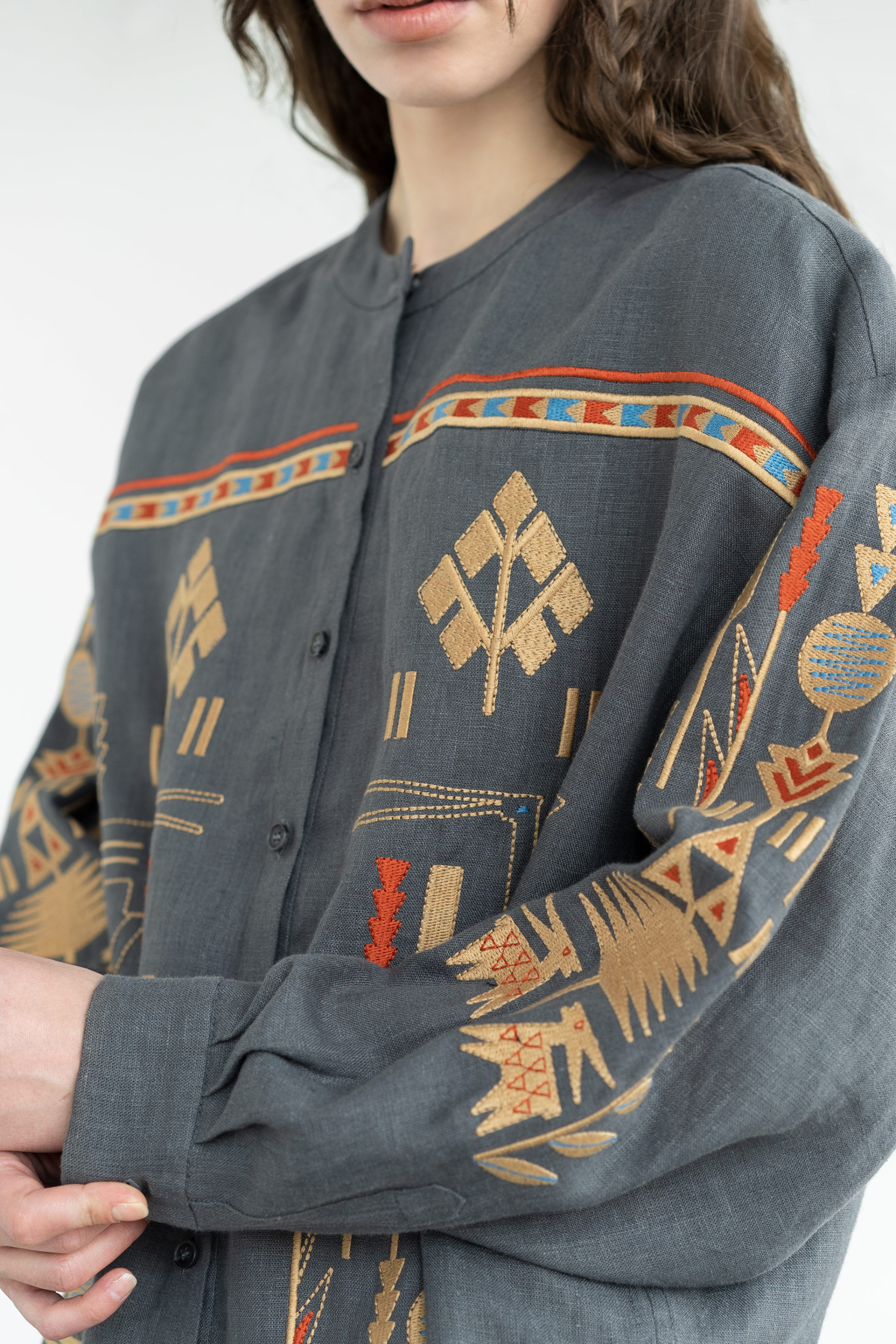 Person wearing a dark gray shirt with colorful geometric patterns on a white background