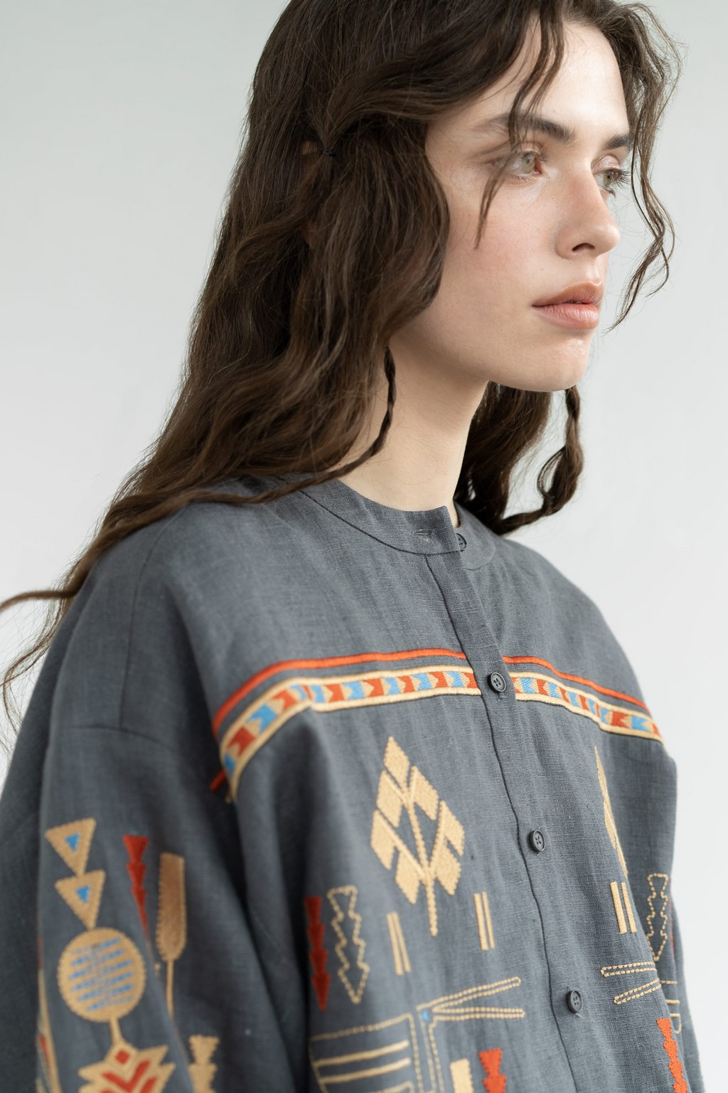 Person wearing a dark gray shirt with colorful geometric patterns on a white background