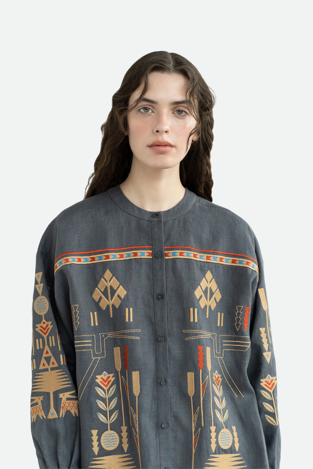 Person wearing a dark gray shirt with geometric patterns on a white background