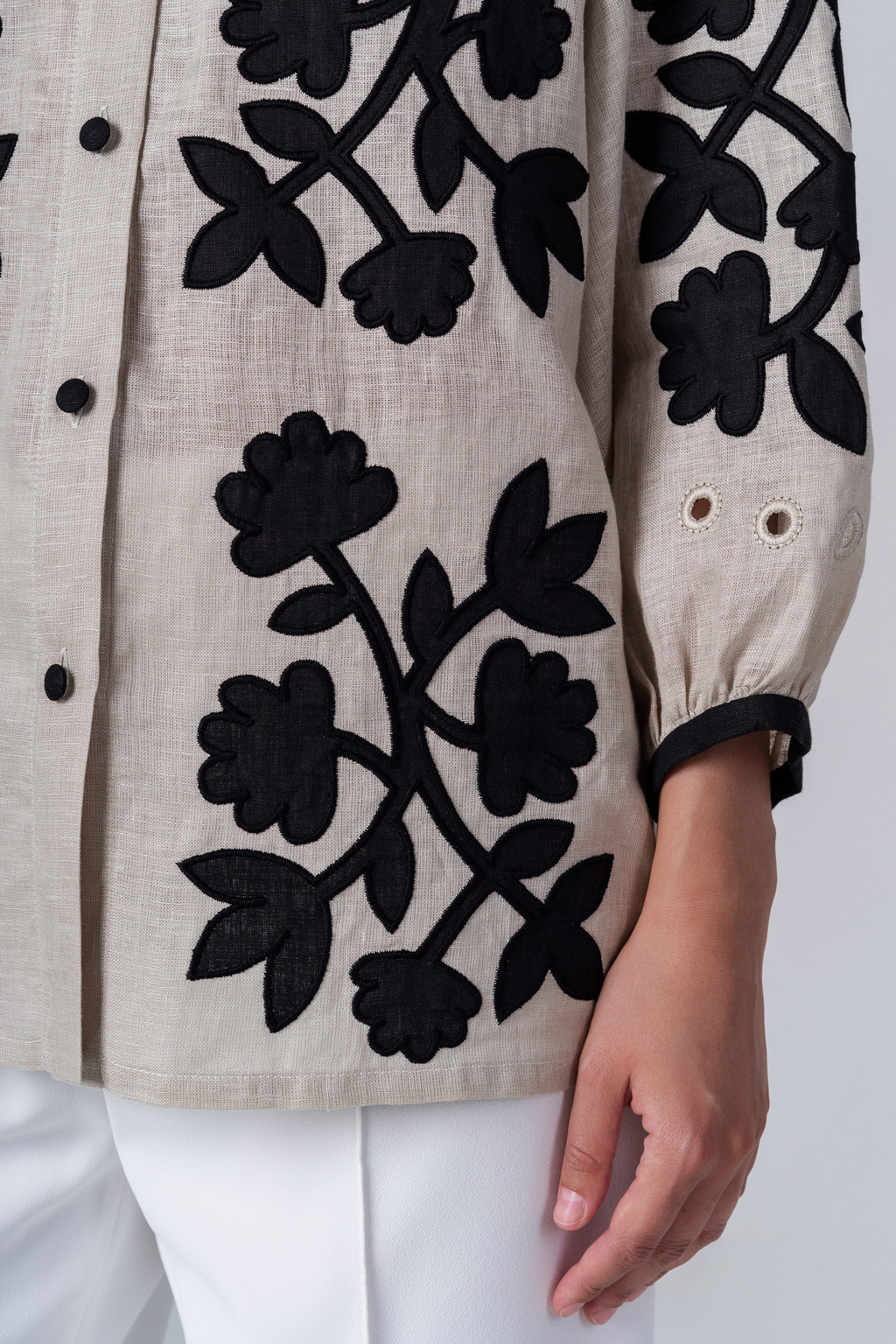 Beige jacket with black floral patterns on a white background